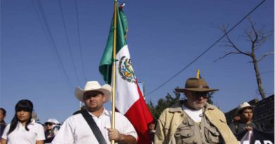 Julián LeBarón sostiene la bandera de México en la Caravana por la Paz