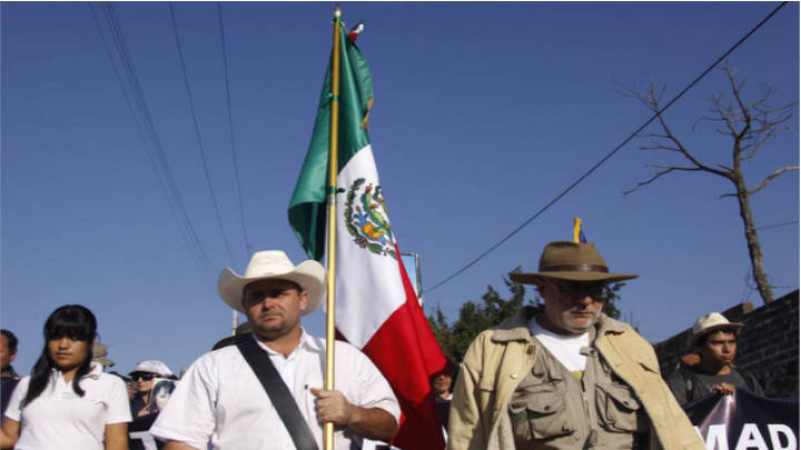 Julián LeBarón sostiene la bandera de México en la Caravana por la Paz